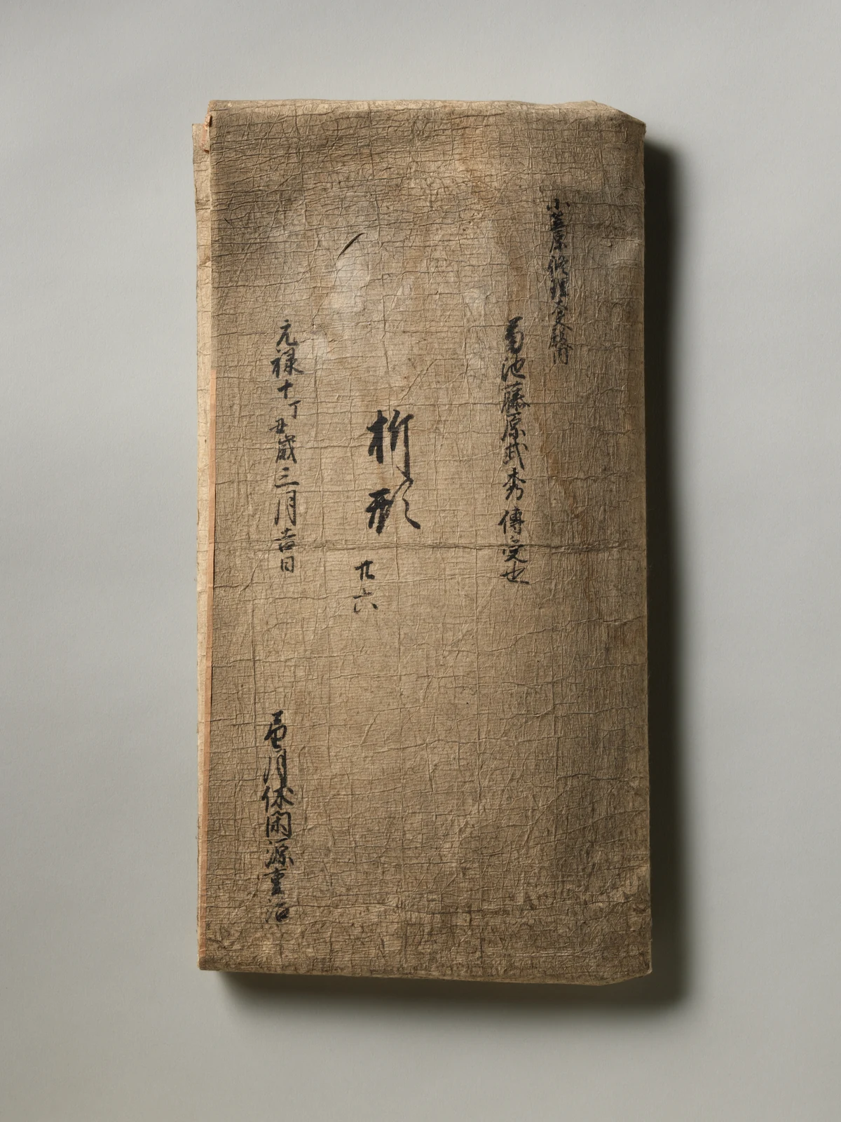 A bound 1697 Japanese manual with an ivory paper cover and vertical handwritten label.